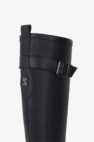 Bota Flur negra Sofia Sarkany: detalle correa con hebilla metálica y logo SS plateado. Elegancia y onda urbana.