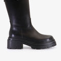 Bota Syra negra de cuero Sofia Sarkany con hebilla plateada al tobillo y suela track. ¡Un fuego para tu look!