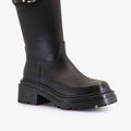 Bota Syra Sofia Sarkany negra de cuero, caña media con hebilla y suela chunky plataforma. ¡Un look bien canchero!