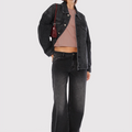 Modelo con Jean Kip Sofia Sarkany negro wide leg lavado, campera denim y top corto. Ideal para un look urbano.