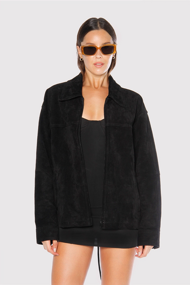 Campera Ken negra de gamuza Sofia Sarkany en modelo mujer con gafas, ideal para un look casual y canchero.
