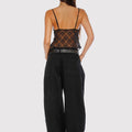 Top Oni Sofia Sarkany de encaje negro visto de espalda. Un look canchero con pantalón ancho para vos.
