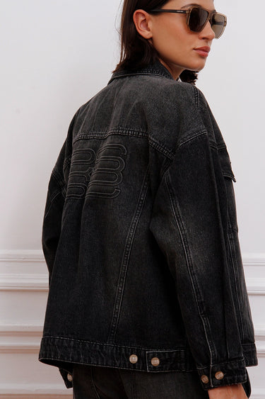 Campera Plar negra Sofia Sarkany de jean lavado, oversized, con bordado canchero en la espalda. Ideal para vos.