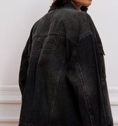 Campera Plar negra Sofia Sarkany de jean lavado, oversized, con bordado canchero en la espalda. Ideal para vos.