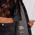 Campera Plar Sofia Sarkany de jean negro, detalle interior con etiqueta y top de encaje. Moda urbana.