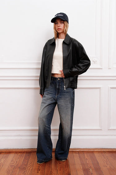 Sofia Sarkany Campera Rume negra bomber de cuero, con cuello y cierres, en un look canchero con jeans de mujer. Moda urbana.