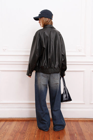 Campera Rume negra Sofia Sarkany, espalda de cuero oversize. Look urbano canchero con jeans anchos y gorra.