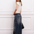 Modelo con jean Strap Sofia Sarkany azul lavado, pierna ancha, remera clara y gorra. Estilo comfy y moderno para mujer.