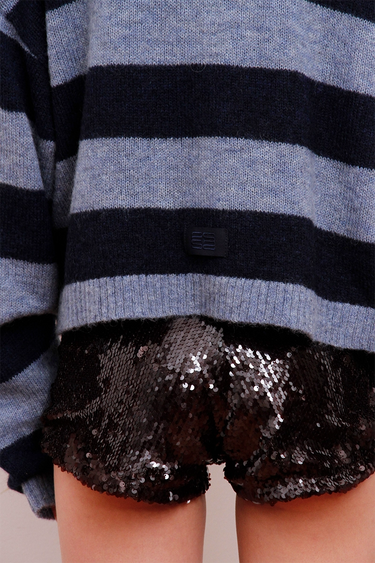 Short Lula negro con lentejuelas brillosas y buzo rayado azul de Sofia Sarkany. ¡Un look canchero!