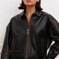 Campera Traf Sofia Sarkany negra efecto cuero, cierres y costuras visibles. Outfit casual urbano.