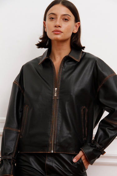 Campera Traf Sofia Sarkany negra efecto cuero, cierres y costuras visibles. Outfit casual urbano.