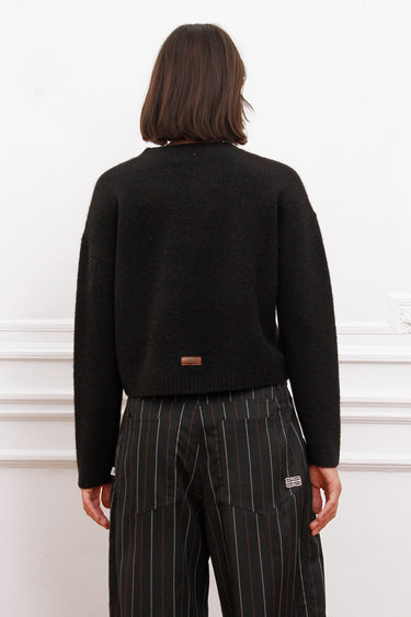 Sweater Bonn negro Sofia Sarkany en modelo de espalda. Pullover de lana, cómodo y canchero para tu look diario.