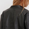 Detalle de la espalda de la campera Alo negra Sofia Sarkany, con el cuello y el logo. Moda femenina versátil y urbana.
