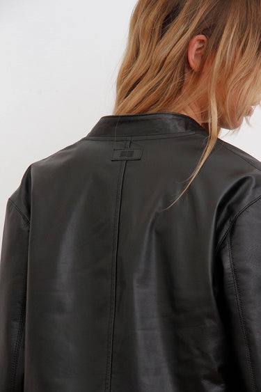 Detalle de la espalda de la campera Alo negra Sofia Sarkany, con el cuello y el logo. Moda femenina versátil y urbana.