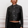 Campera Alo de cuero negra Sofia Sarkany, diseño cropped con botones blancos. Abrigo urbano para vos.